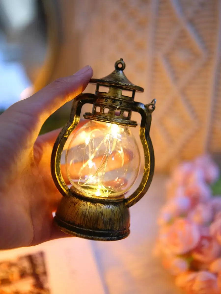 Vintage LED kerosene lantern with warm fairy lights and aged bronze finish.
