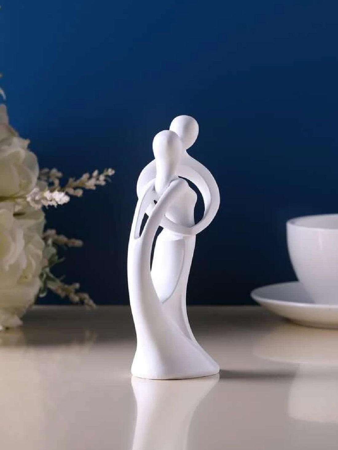 Add a touch of modern elegance to any room with this sandstone resin couple figurine. Perfect for home decor or as a thoughtful wedding gift, this minimalist design exudes sophistication and charm. Crafted from high-quality material, this figurine is a timeless addition to any space.