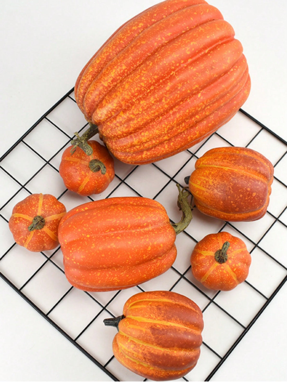 Add a touch of festive charm to your home this fall with our 7-8 piece set of assorted sized artificial fake orange pumpkins. Perfect for both Thanksgiving and Halloween decorations. Made with high-quality materials for a realistic look. Upgrade your seasonal decor with ease.