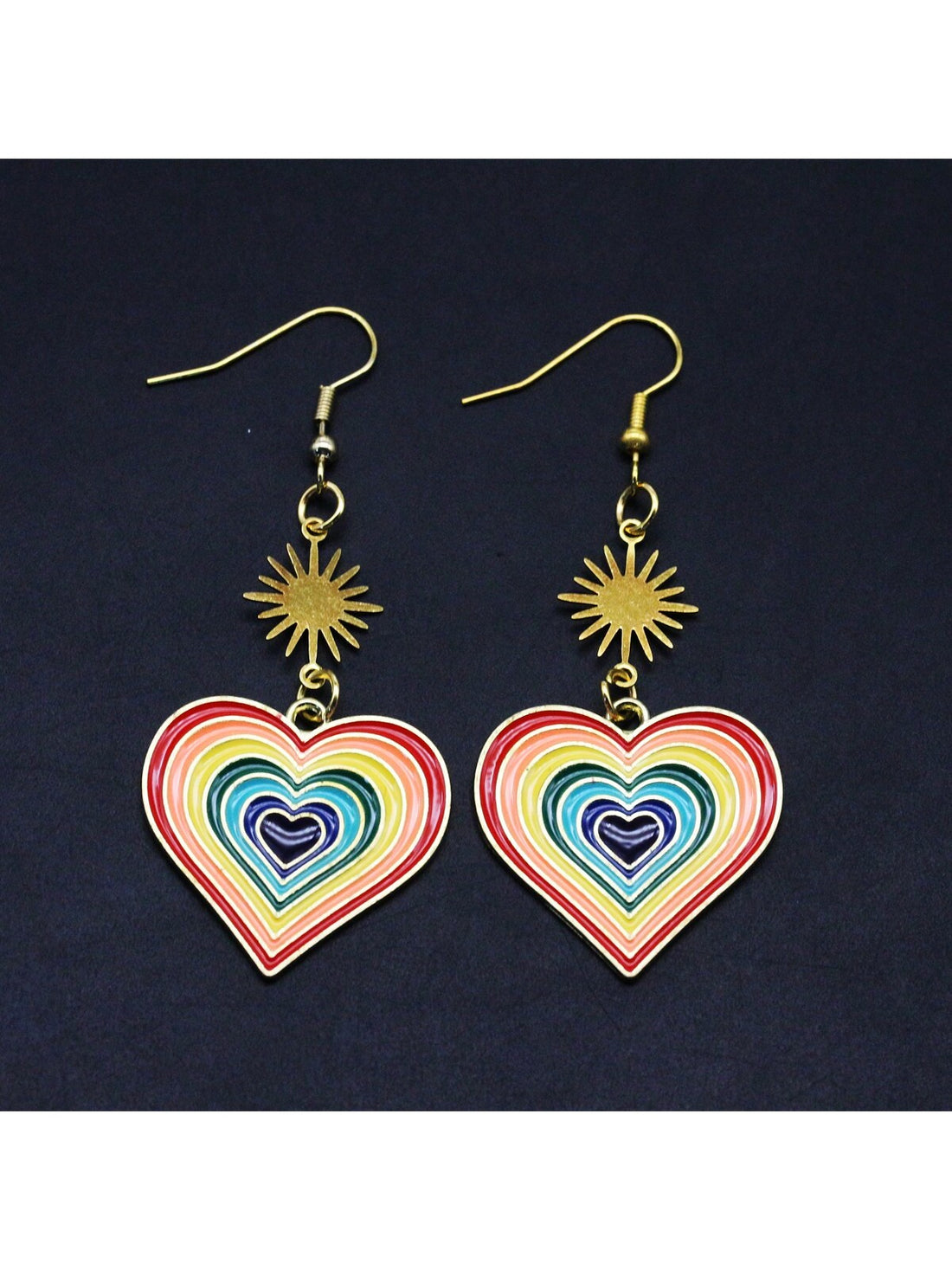 These Rainbow Heart Pride Earrings celebrate LGBTQ love with colorful enamel pendants and dangle hooks. Embrace individuality and show support for the community with this symbolic accessory. Perfect for both casual and formal wear, these earrings make a statement of love and acceptance.