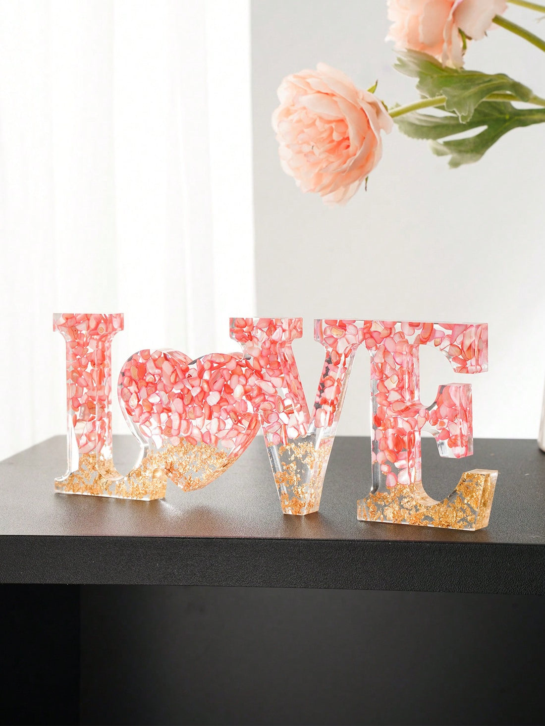 The Bohemian Love Tabletop Decoration is a stunning piece of art, handmade with acrylic material and embellished with natural pebbles and a touch of golden powder. Bring a touch of bohemian charm to your space while adding a unique and elegant decoration to your tabletop.