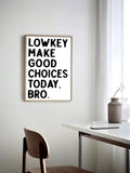 Light wood framed Make Good Choices typography print above a minimalist desk