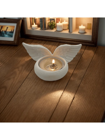 White wing shaped candle holder with carved feather texture and warm tealight glow.