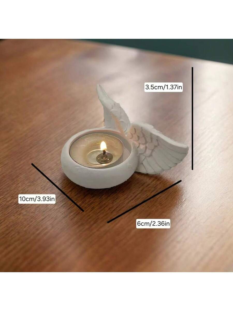 Angel wing tealight holder on wood table with white matte finish.