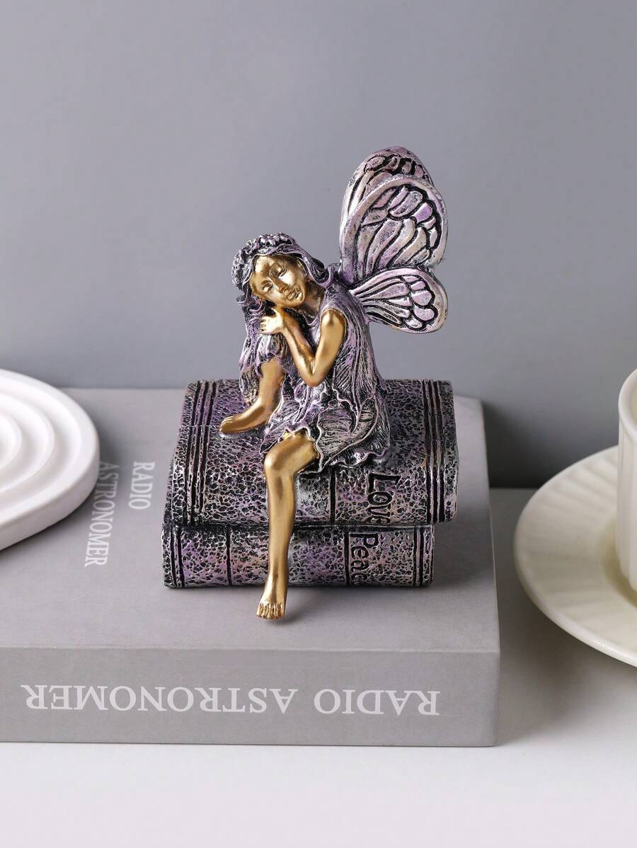 Close-up of fairy decor showing textured wings, book pages, and distressed patina.