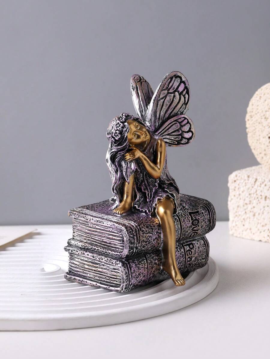 Fantasy reading ornament displayed on grey book and white tray.