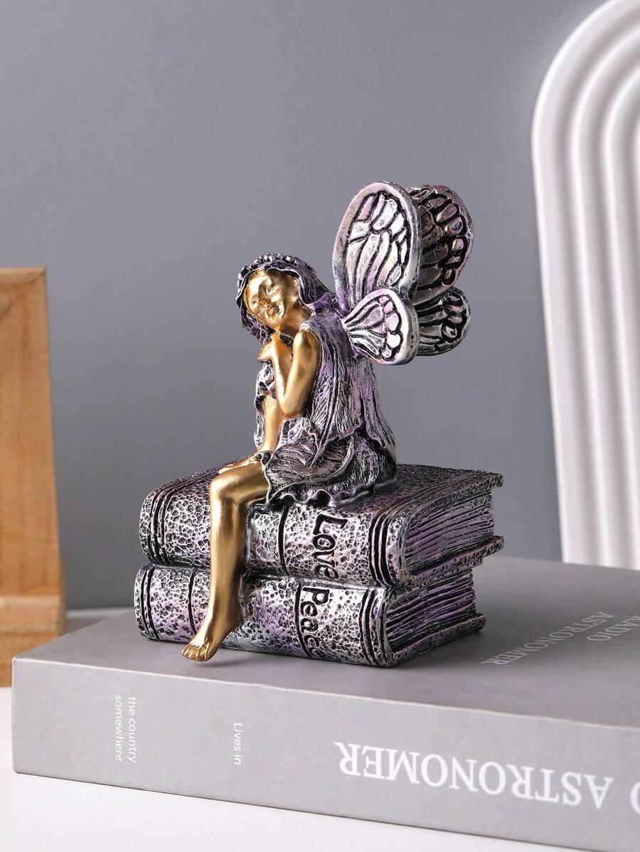 Antique silver and gold fairy bookcase ornament shown from side angle.