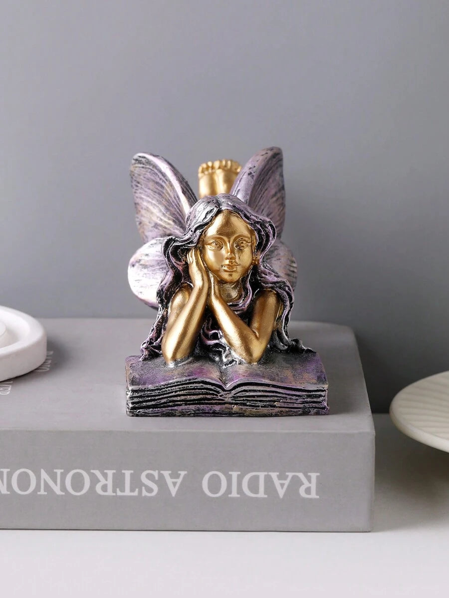 Resin book-shaped angel decor with fairy lying on open book.