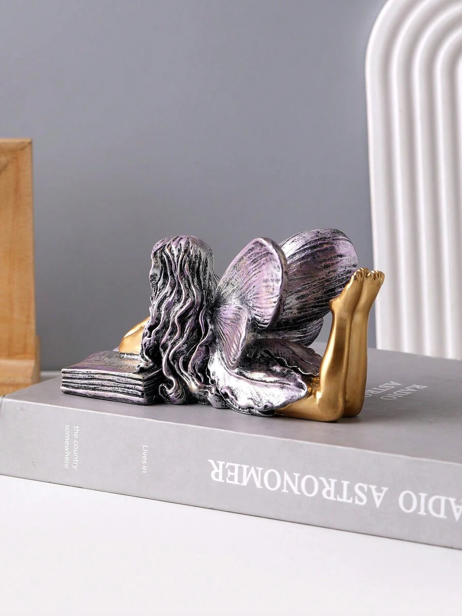 Two book-themed angel ornament variants shown together on tabletop.