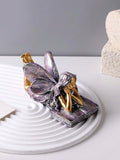 Resin book-shaped angel decor with fairy lying on open book.