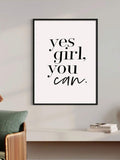 Black framed Yes Girl You Can typography art above a console and woven chair