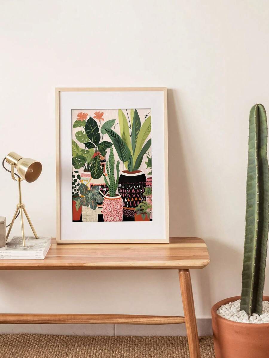 Matted tropical planter artwork beside task lamp and potted cactus