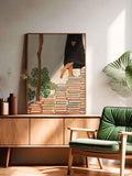 Framed book staircase illustration displayed in a sunlit living room