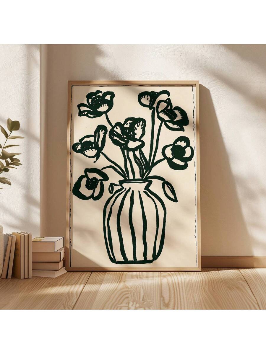 Bold dark green flower vase line art print leaning on wood floor in sunlight