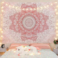 Pink and white mandala tapestry displayed above bed with warm string lights and pastel bedding