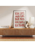 Red lettered Spanish quote print on a mid-century credenza beside a radio and ceramic lamps