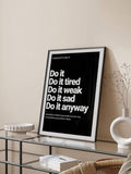 Framed consistency quote poster on glass console with white sculptural vase