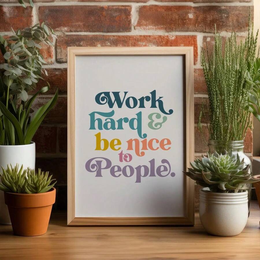 Inspirational quote wall art in a wood frame beside green plants
