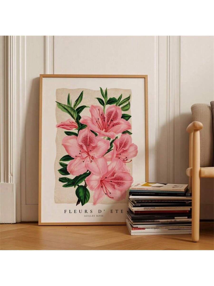Pink azalea botanical artwork displayed on a wood floor beside stacked books and a chair
