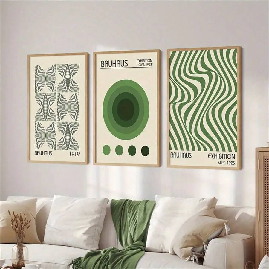 Three framed Bauhaus inspired posters displayed above a neutral bed