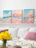 Pastel coastal canvas triptych displayed on shelf above white sofa with pink pillow and yellow flowers