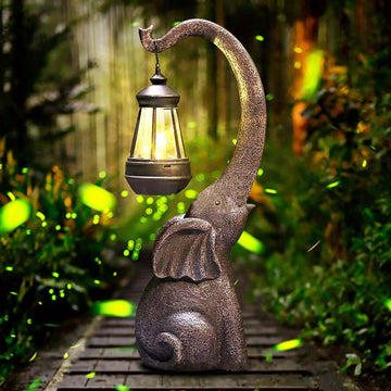 Solar elephant garden lantern statue with warm light and bronze gray resin body.