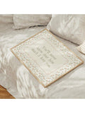 Pastel botanical love quote artwork styled on neutral bedroom bedding