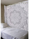Gray white mandala tapestry wall hanging styled above bed with boho bedroom decor