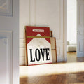 Vintage French love poster in a gold frame leaning against a paneled wall