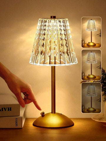 Cordless rechargeable gold LED table lamp glowing on dining table.
