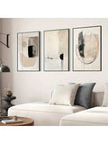 Black beige abstract triptych above a gray sectional sofa