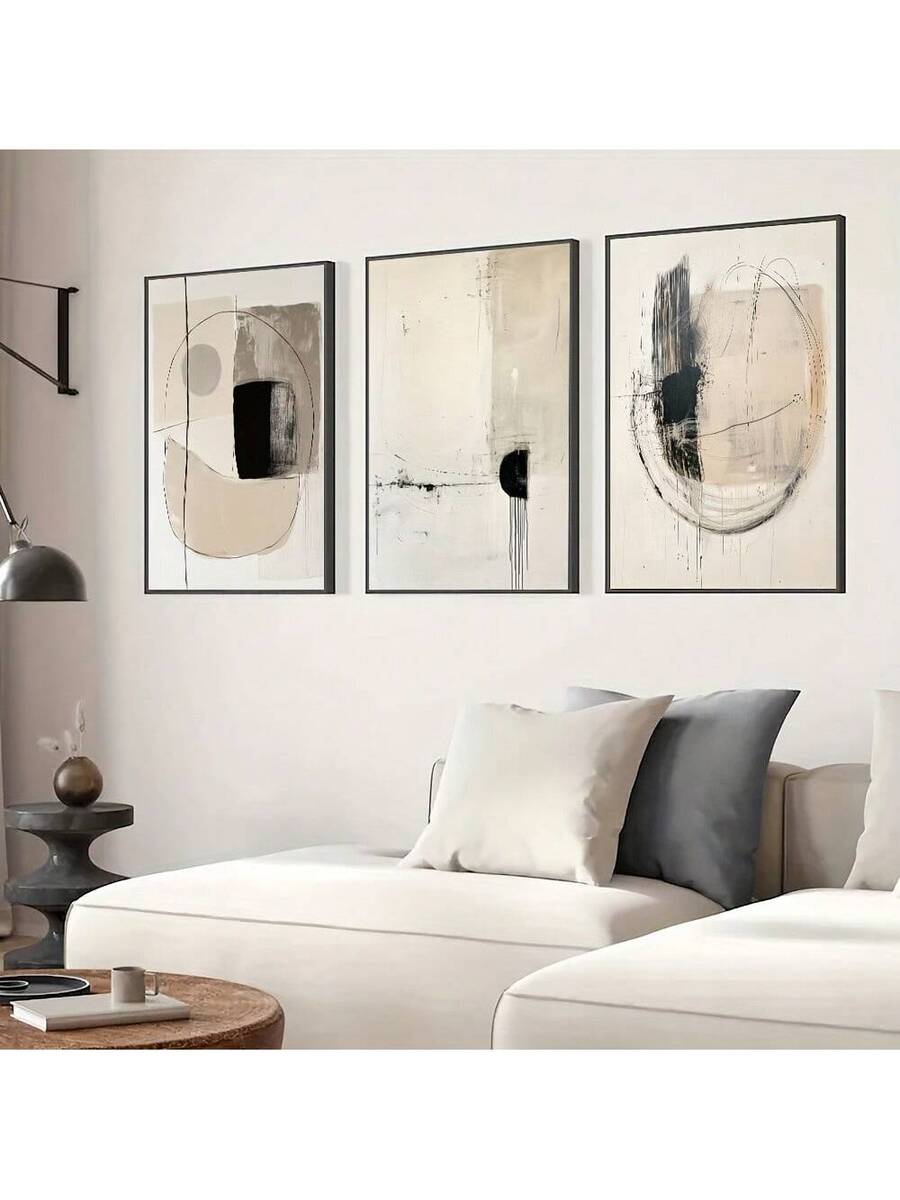 Black beige abstract triptych above a gray sectional sofa