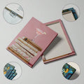 Pink book stack art with floral covers and soft glam style
