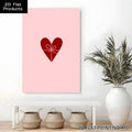 Pink heart gift bow canvas wall art displayed above bench with plant and baskets in neutral room