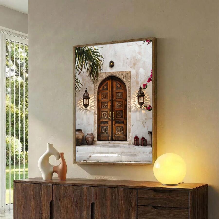 Brown wood framed architectural wall art over a dark credenza showing an ornate doorway lanterns steps pottery and flowers