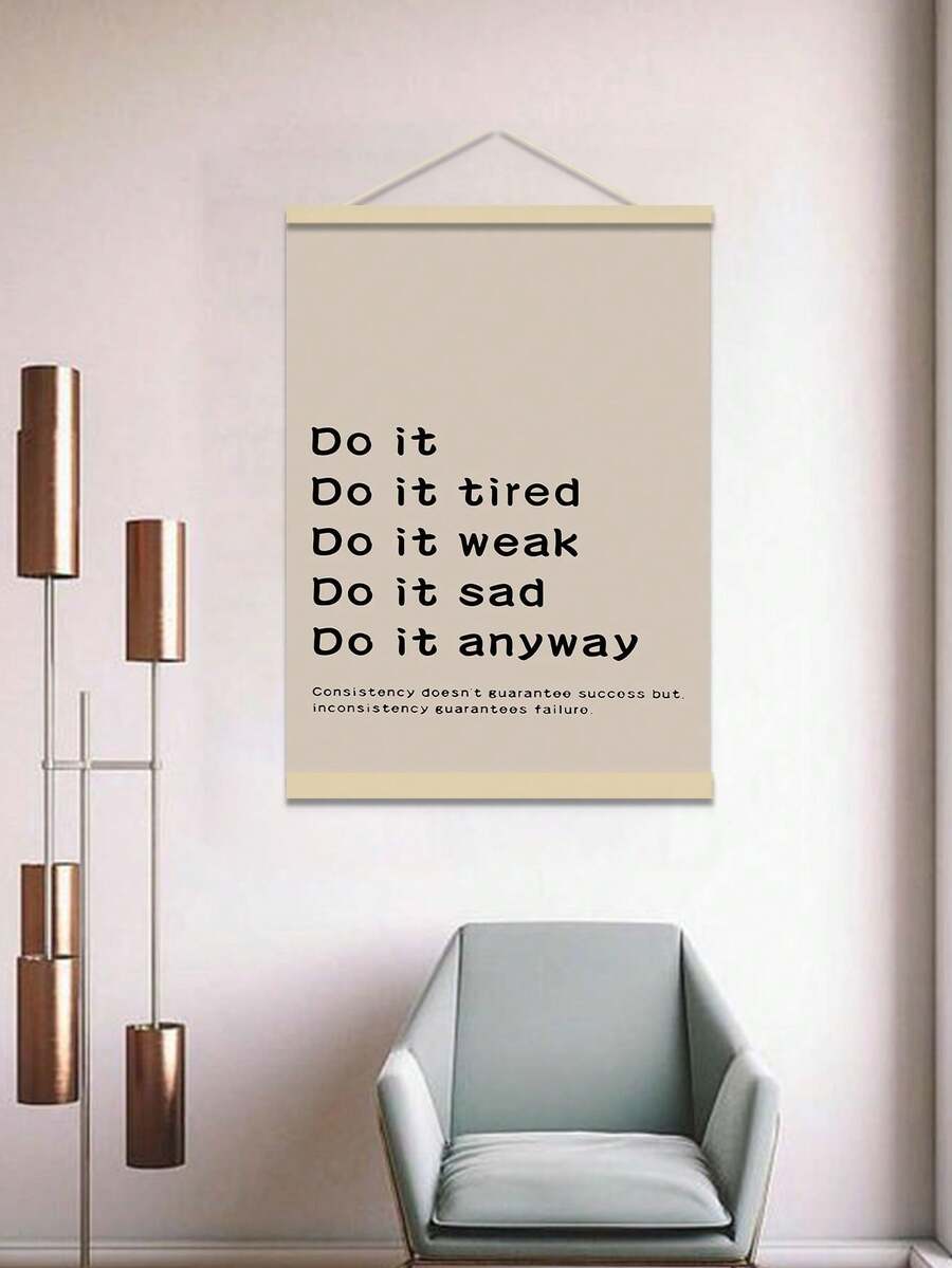 Hanging beige consistency poster above chair with modern floor lamp