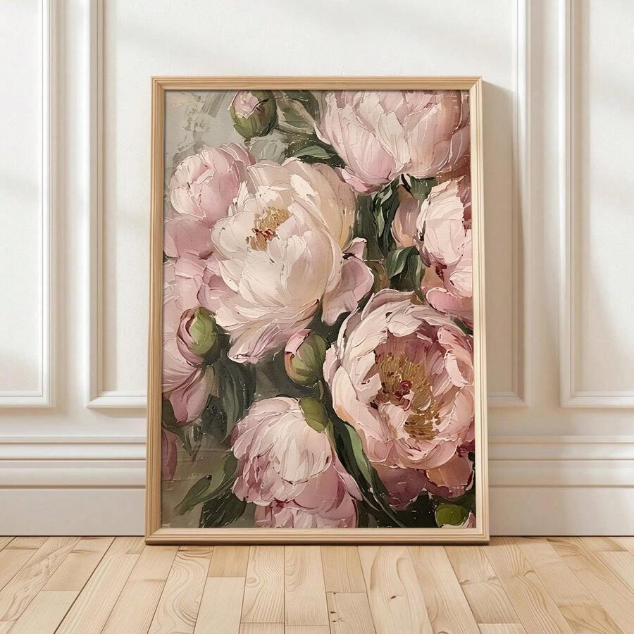 Pink peony floral canvas print in light wood frame leaning on white wall beside potted plant