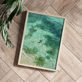 Framed turquoise abstract swimmer print shown as a styled flat-lay