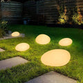 Solar garden lights warm glow along lawn and pathway landscape scene