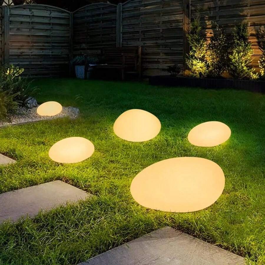 Solar garden lights warm glow along lawn and pathway landscape scene