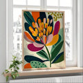 Colorful botanical poster in a light wood frame displayed on a bright window ledge
