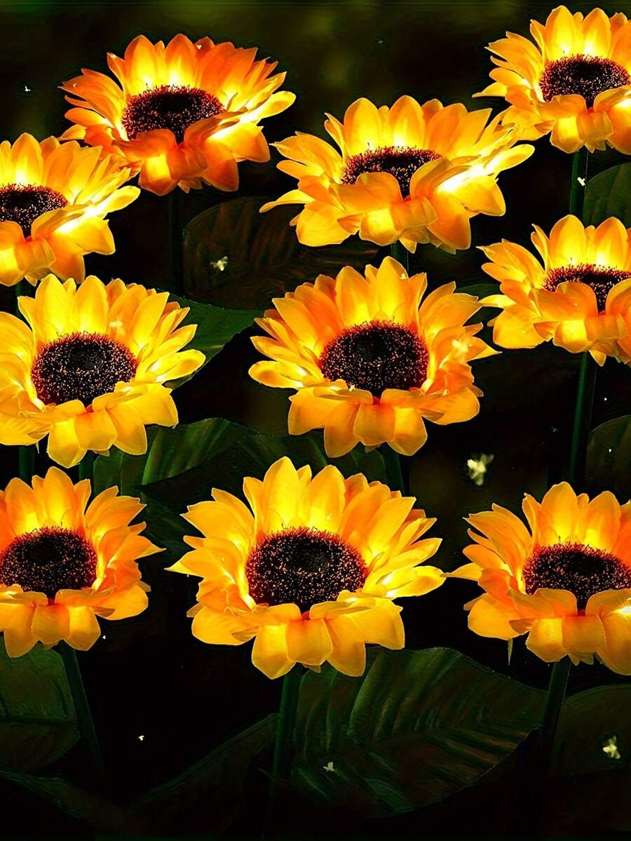 Multiple yellow sunflower solar lights shining at night outdoors
