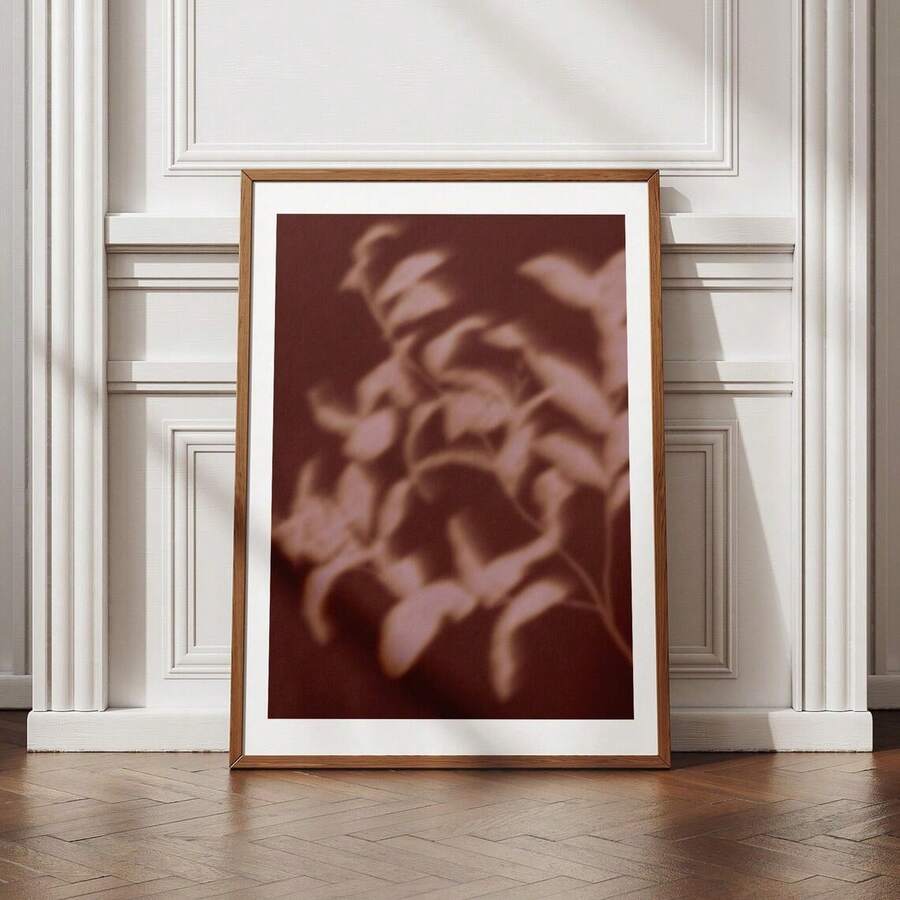 Abstract shadow leaf wall art in a black frame with a white mat