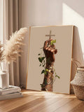 Framed cross and vine wall art beside pampas grass and books