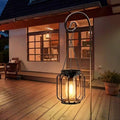 Two solar hanging pendant lights glowing warm yellow on patio hooks.