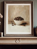 Moody coffee bean artwork in ornate dark frame on mantel