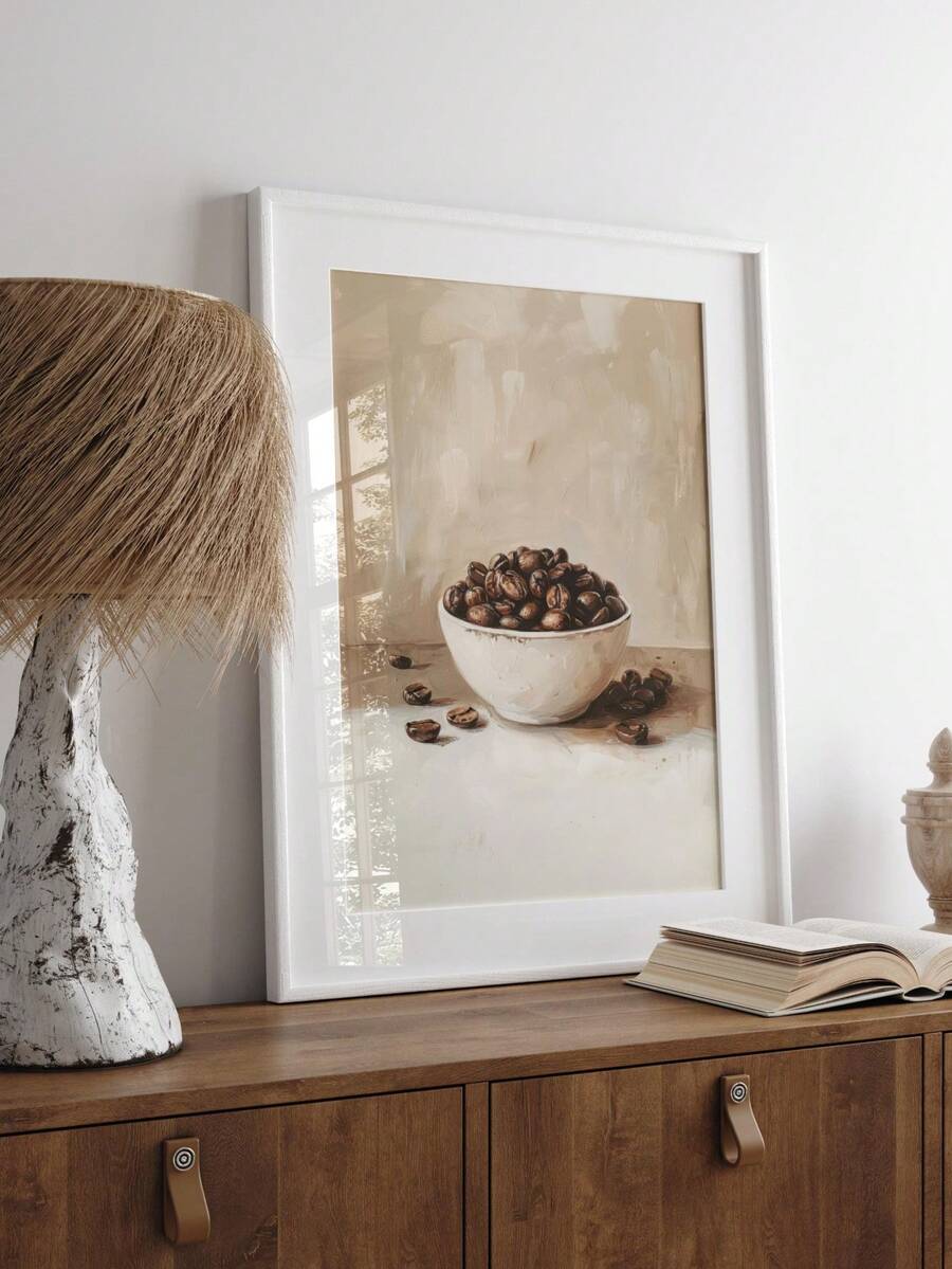 White framed coffee bean still life on wood console beside lamp and open book