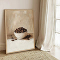 Large framed coffee bean cafe poster leaning on floor near sheer curtains