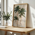 Framed palm botanical artwork on wooden desk near window and vase