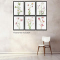 Six vintage botanical flower prints in a grid on a textured wall